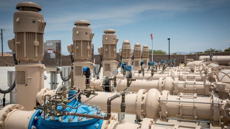 A line of blue and white pipes in a field.